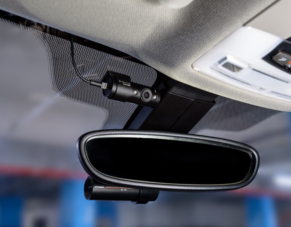 A BlackVue camera mounted discreetly beside the rearview mirror with a second BlackVue unit below it